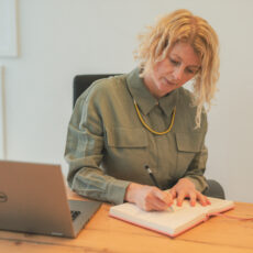 Jen McCanna writing on paper at desk